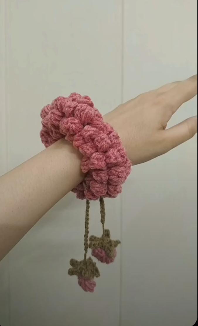 Red crochet scrunchie bracelet worn on wrist